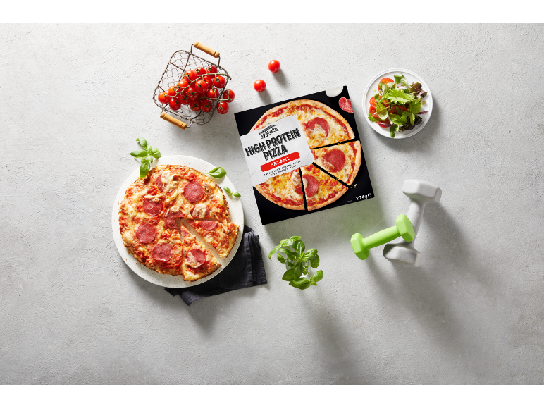 Højprotein salami pizza, frisk basilikum, cherrytomater, salat og håndvægte.