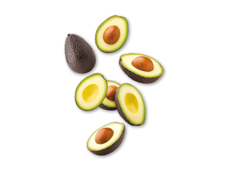Hele og halverede avocadoer, der svæver på en sort baggrund.