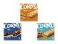Tre pakker müslibarer i forskellige smagsvarianter: jordnød, cookies & cream og saltkaramel.