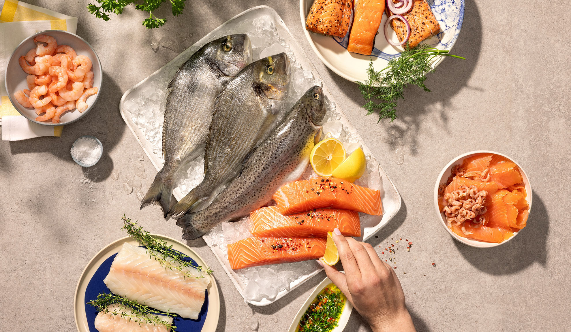 Assorterede friske skaldyr, herunder fisk, laks og rejer, klar til madlavning.