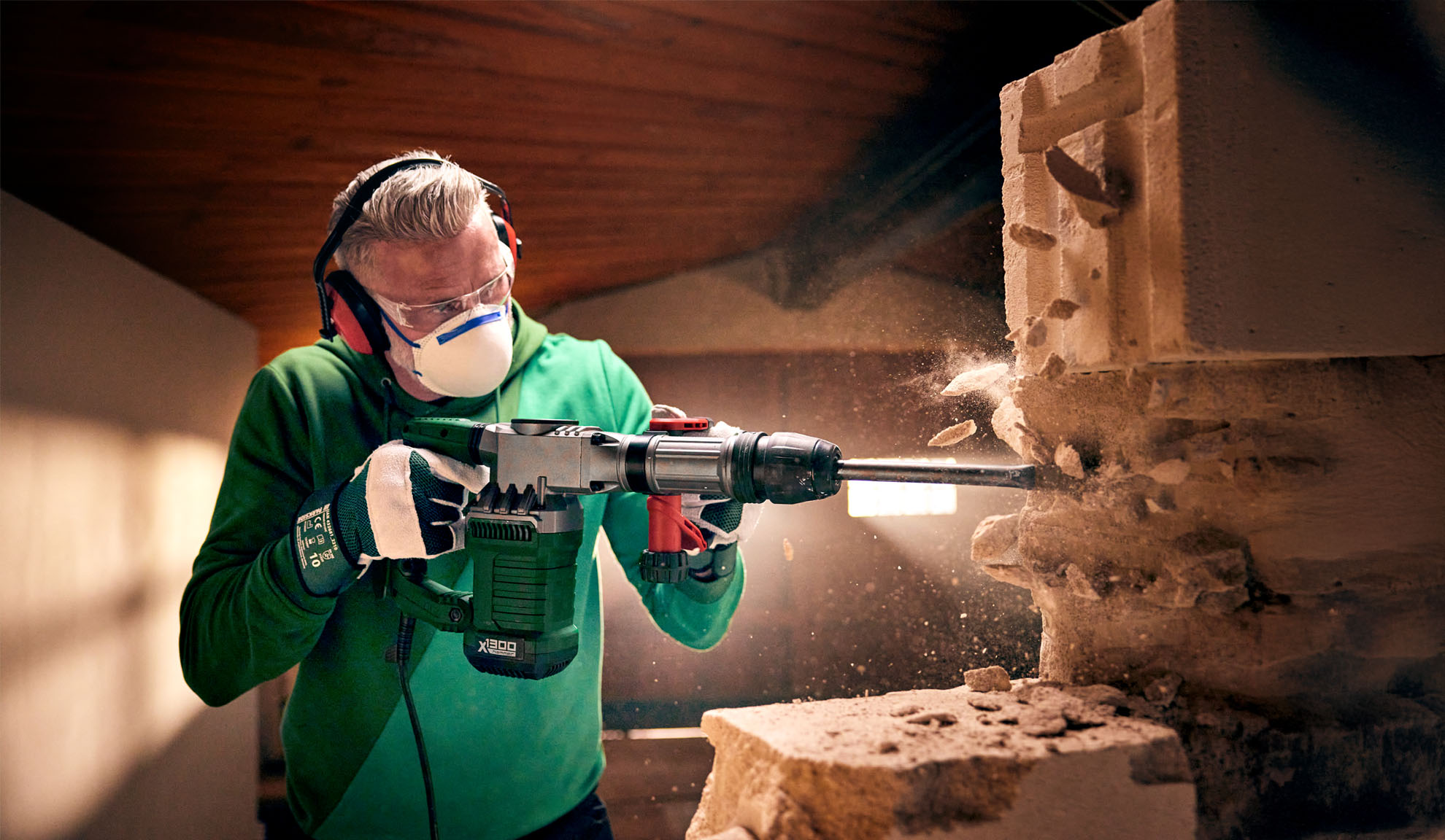 En mand bruger en Worx X-BRUSHLESS nedrivningshammer til at ødelægge en betonblok.