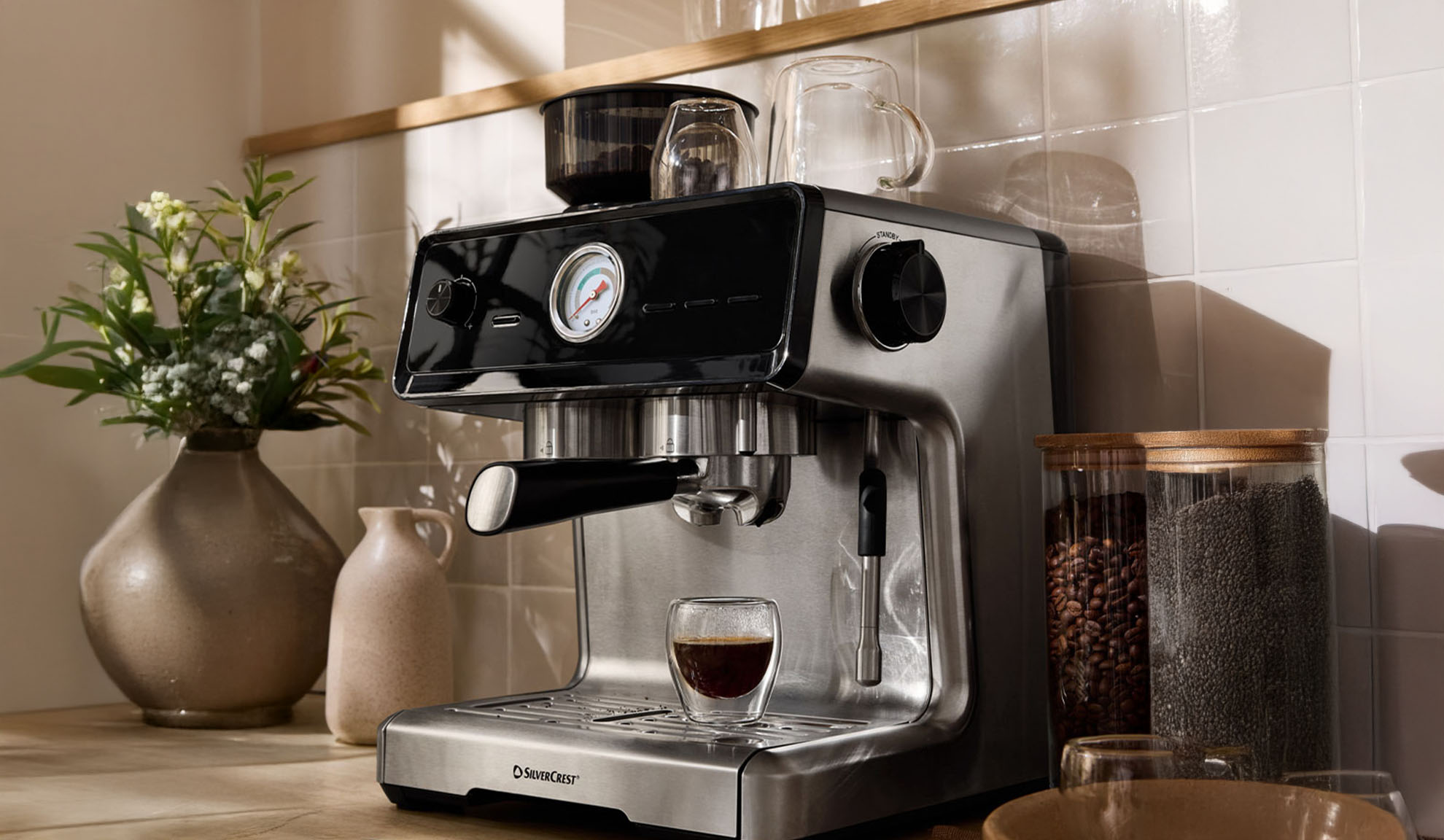 SilverCrest espressomaskine på et køkkenbord med kaffebønner og chiafrø.