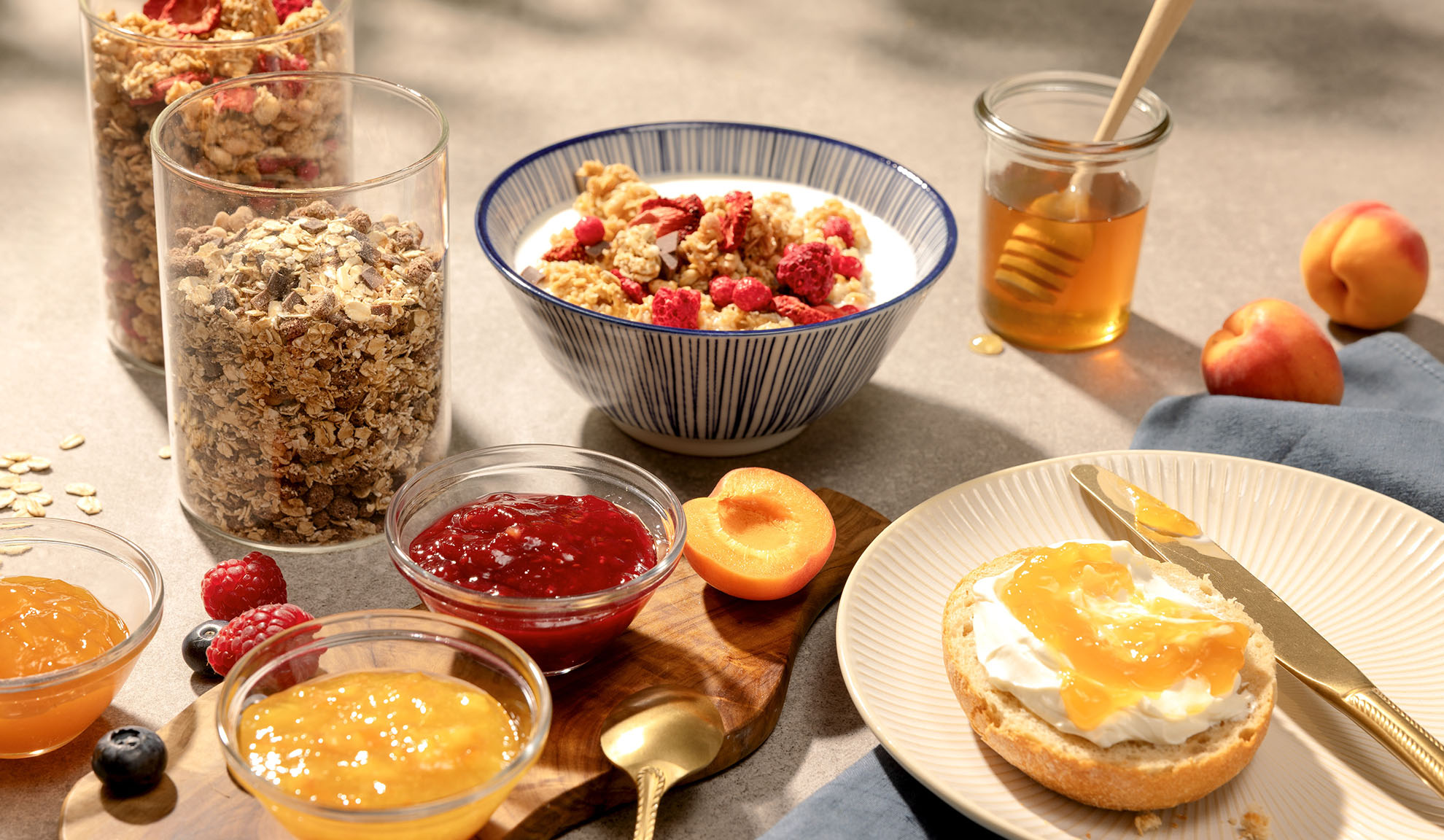 Morgenmad med granola, honning, syltetøj og frisk frugt.