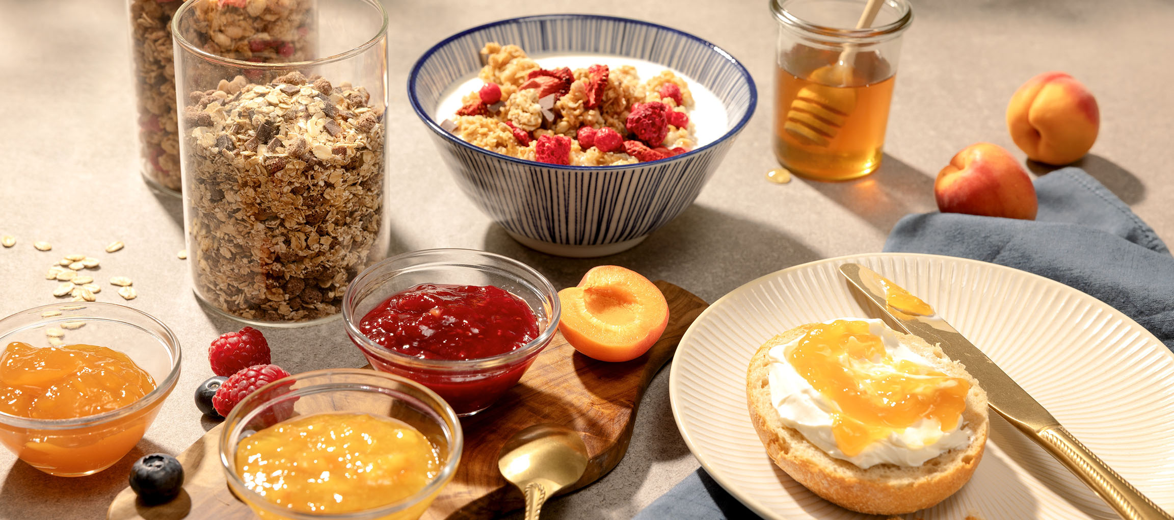 Morgenmad med mysli, syltetøj, honning og brød med flødeost og syltetøj.