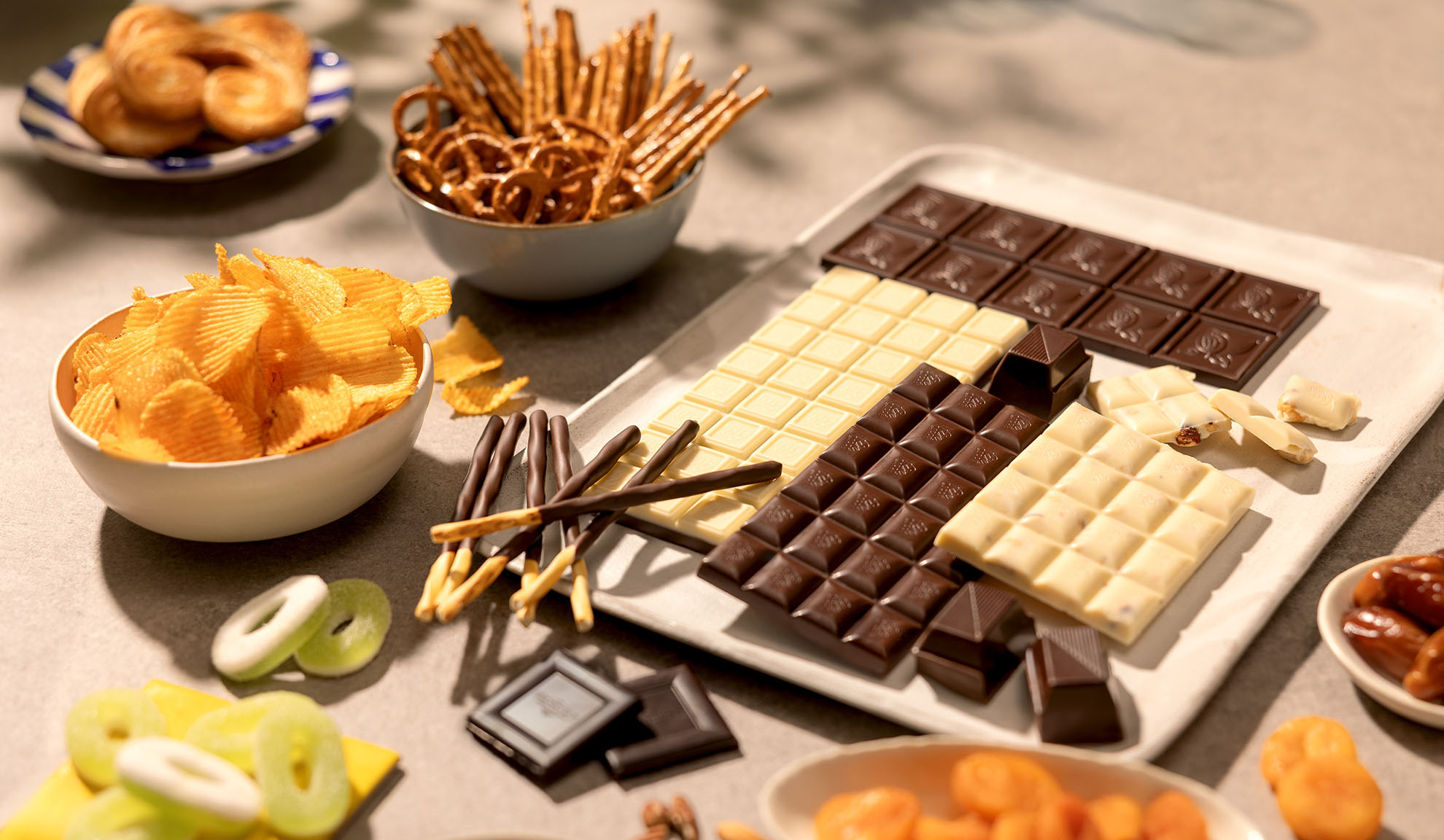 Et udvalg af snacks, herunder chokoladebarer, kartoffelchips, saltkringler og slik.