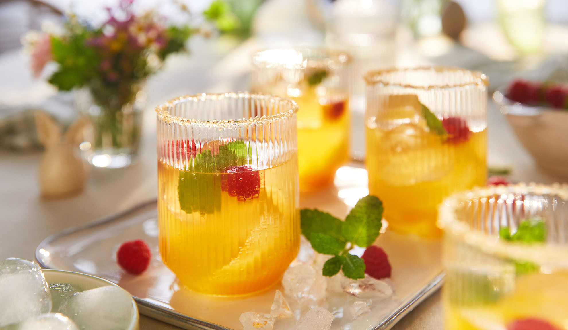 Forfriskende sommerdrinks med hindbær og mynte, serveret på en bakke med is.