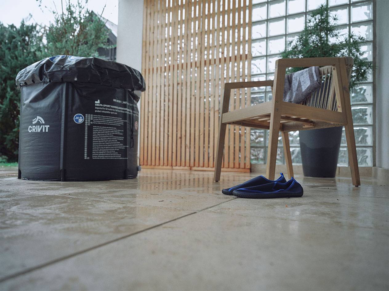 Crivit oppustelig pool og badesko på en terrasse.