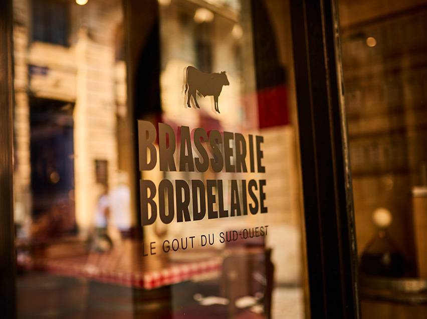 Brasserie Bordelaise-skilt med en ko-silhuet og teksten 'Le Goût du Sud-Ouest'.