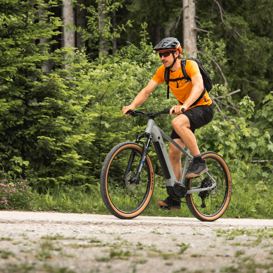 Mand cykler på el-cykel på skovsti.