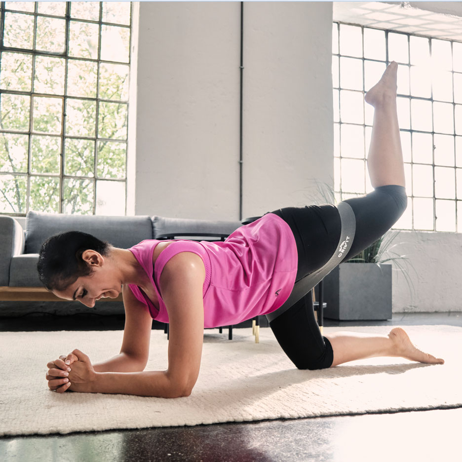 Kvinde laver benøvelser med Senfit resistance band.