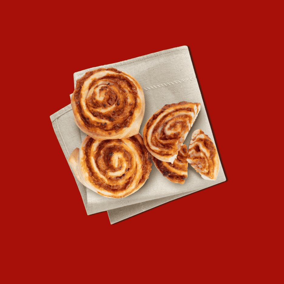 Pizzasnegle på en beige serviet, med en delt snegl der viser fyldet.