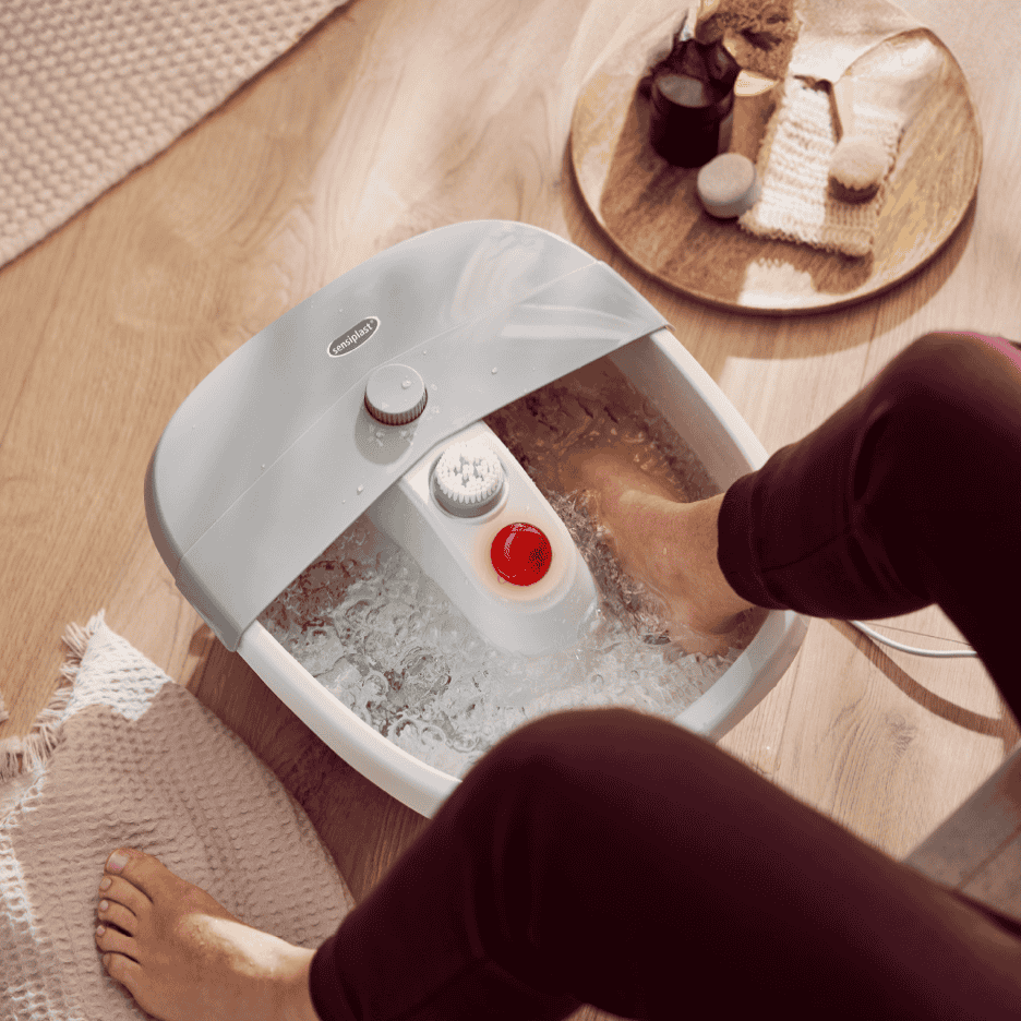 Sensiplast fodspa med bobler og varme, en person nyder et fodbad.