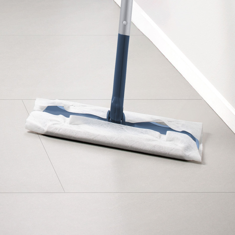 En moppe med en hvid engangsklud på et lyst flisegulv.