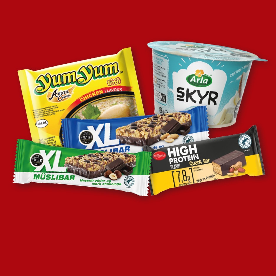 En rød baggrund med instant nudler, yoghurt og forskellige müslibarer.