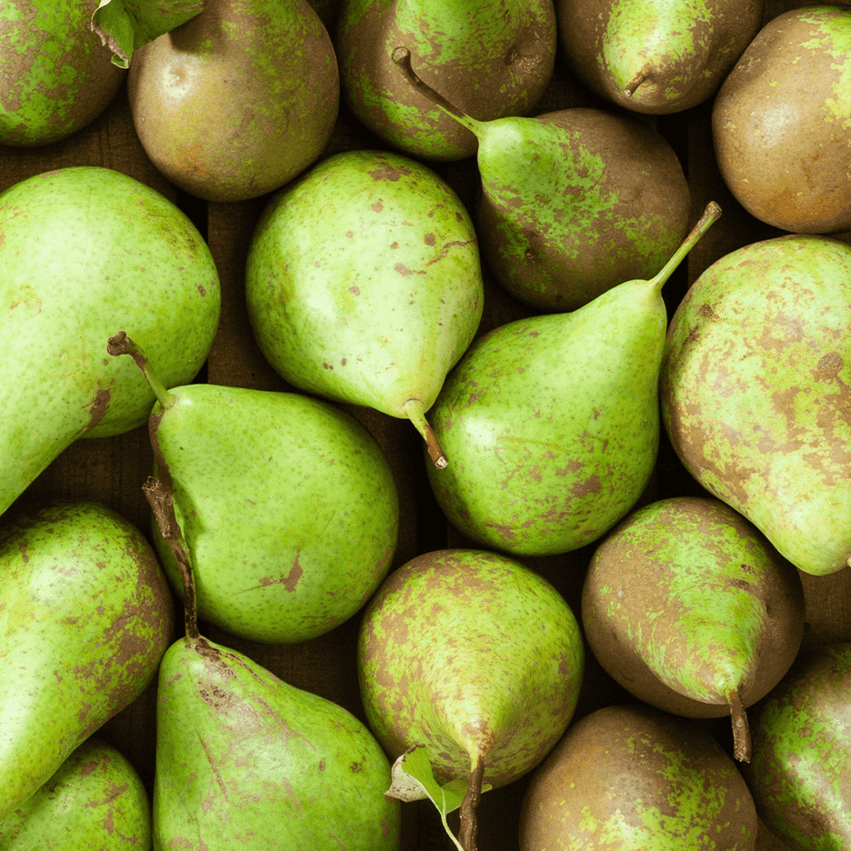 Nærbillede af en bunke grønne pærer med brune pletter.