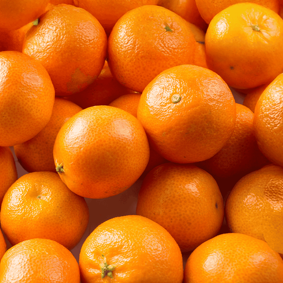 Et nærbillede af en bunke friske, modne mandariner.
