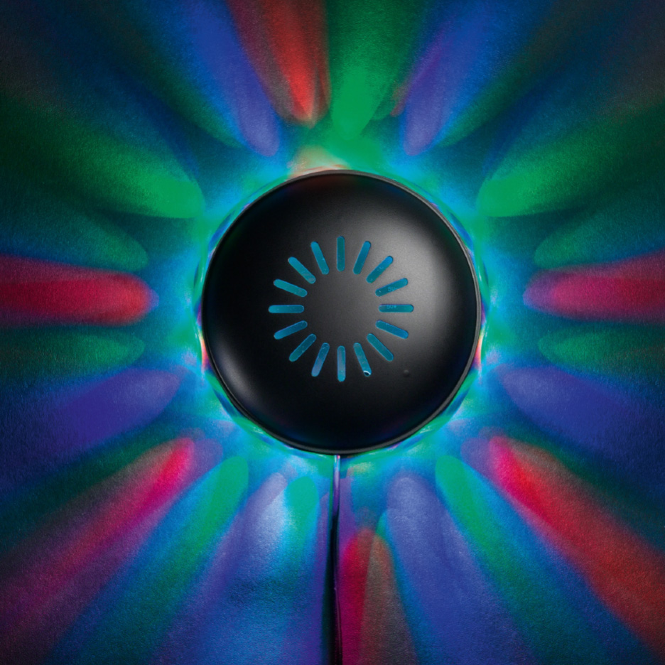 Diskolampe med farverige lysstråler, der projiceres ud fra en sort, rund enhed.