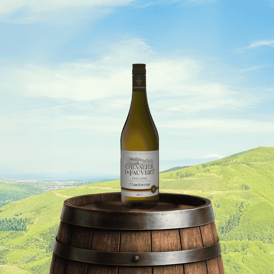 Hvidvin på en vintønde med en vinmark og blå himmel i baggrunden.