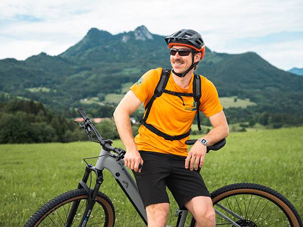 Elcykel og cyklist i et bjerglandskab.