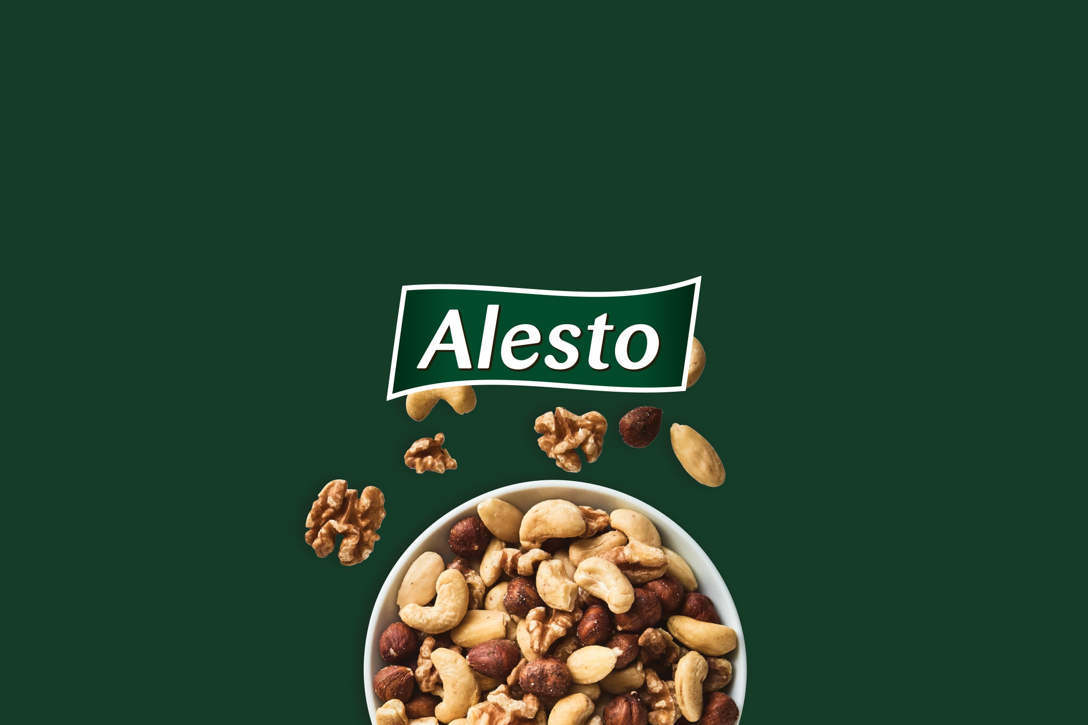 En skål med blandede nødder, herunder cashewnødder, hasselnødder og valnødder, på en mørkegrøn baggrund.