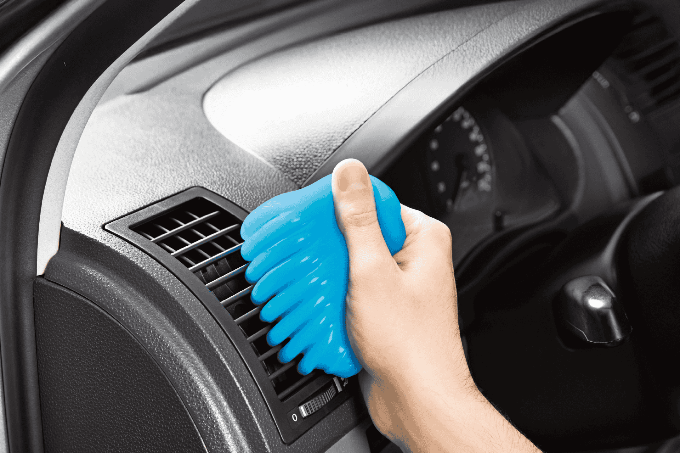 Hånd der rengør bilens luftventil med blåt rensegel.