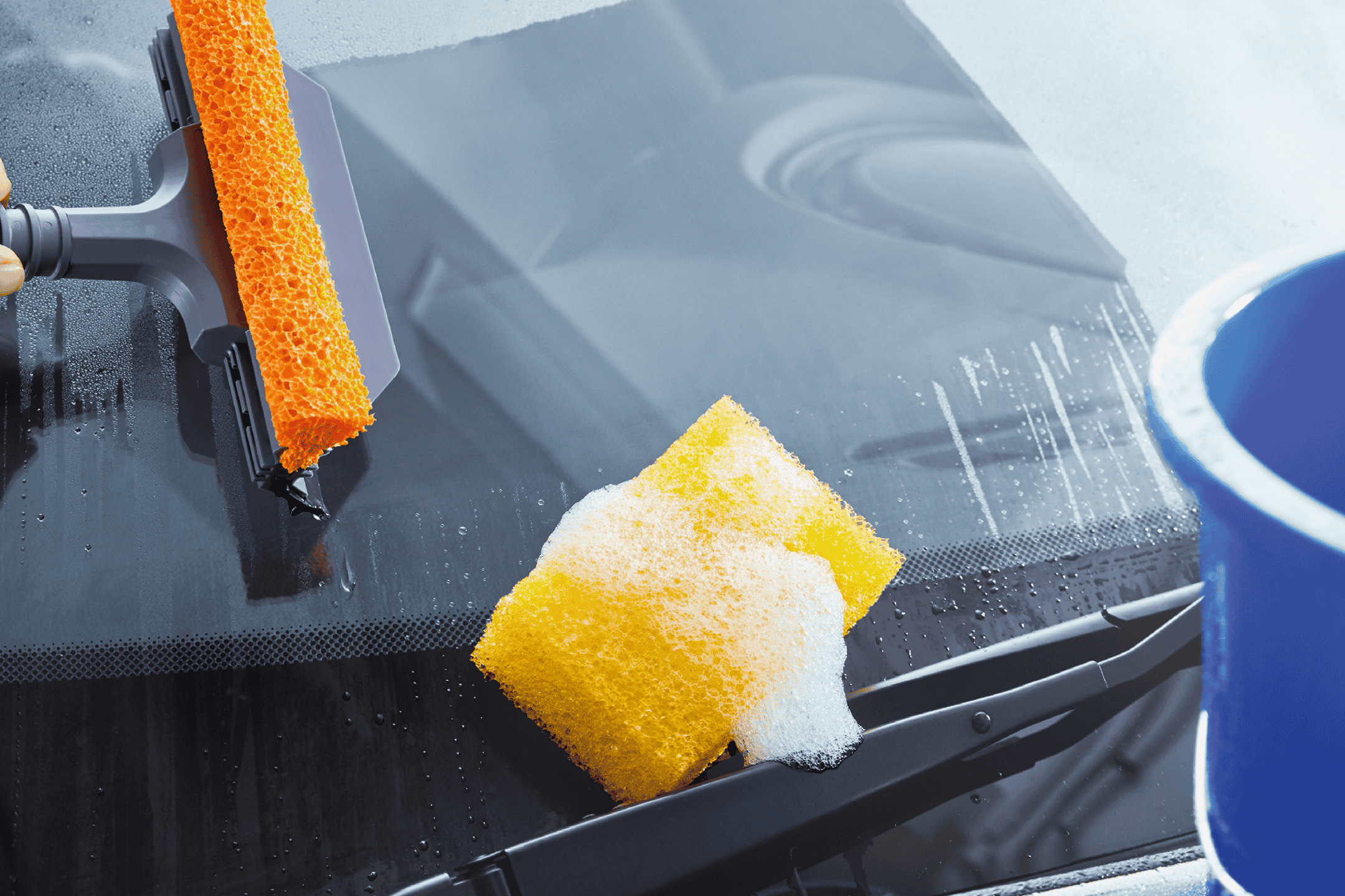 Bilrude vaskes med en orange svaber og gul svamp med sæbeskum.