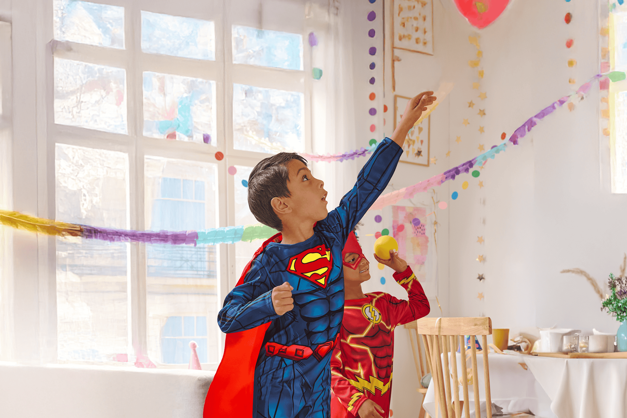 To drenge i Superman- og Flash-kostumer leger til en fest.