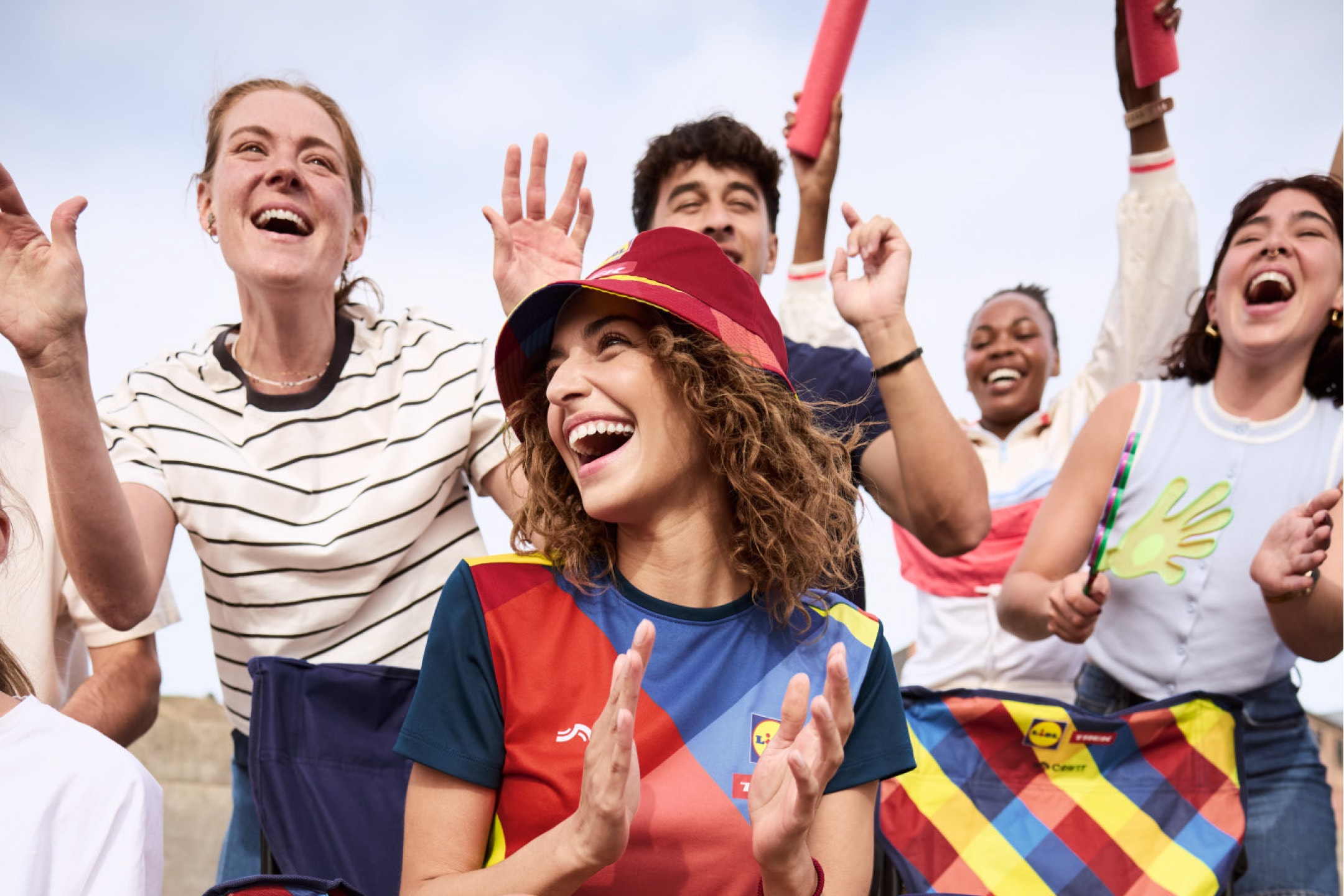 Glade fans i farverigt sportstøj og en matchende klapstol, der hepper.