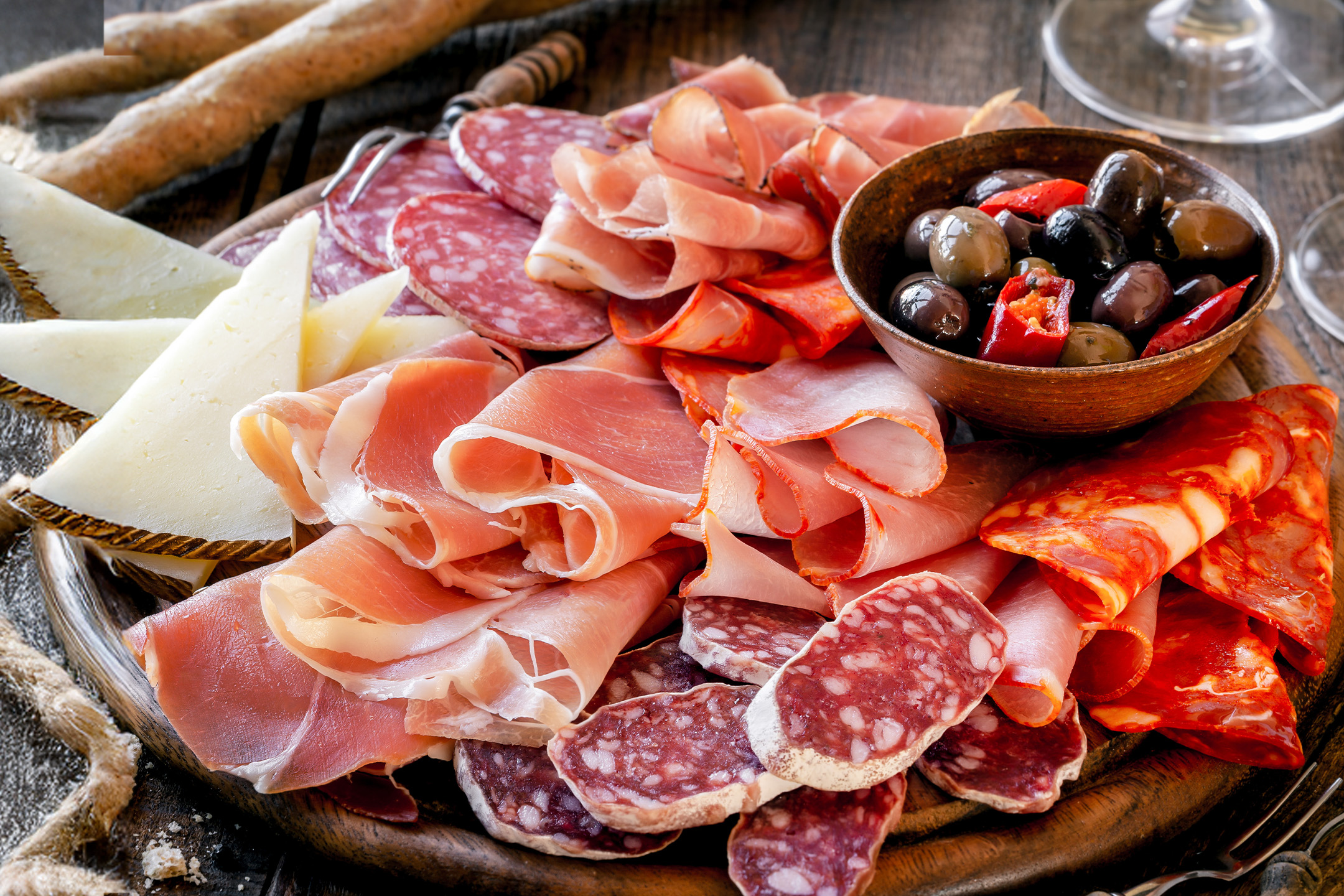 Et fad med spansk tapas, herunder skinke, salami, chorizo, ost og oliven.