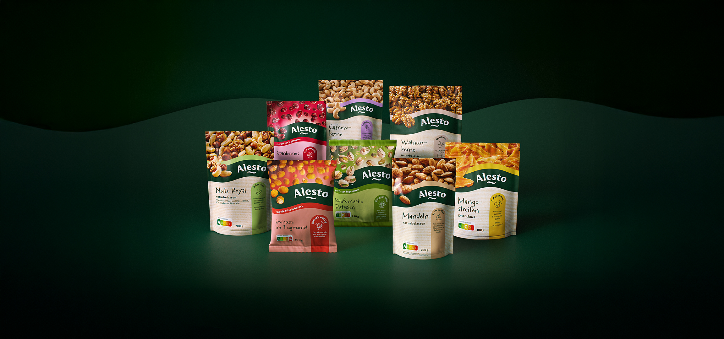 Forskellige snackposer med nødder, tørret frugt og smagsfulde peanuts på en mørkegrøn baggrund.
