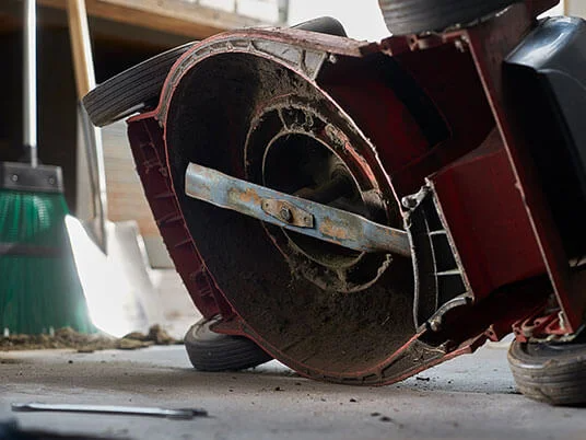 Beskidt plæneklipper på hovedet, med synligt blad