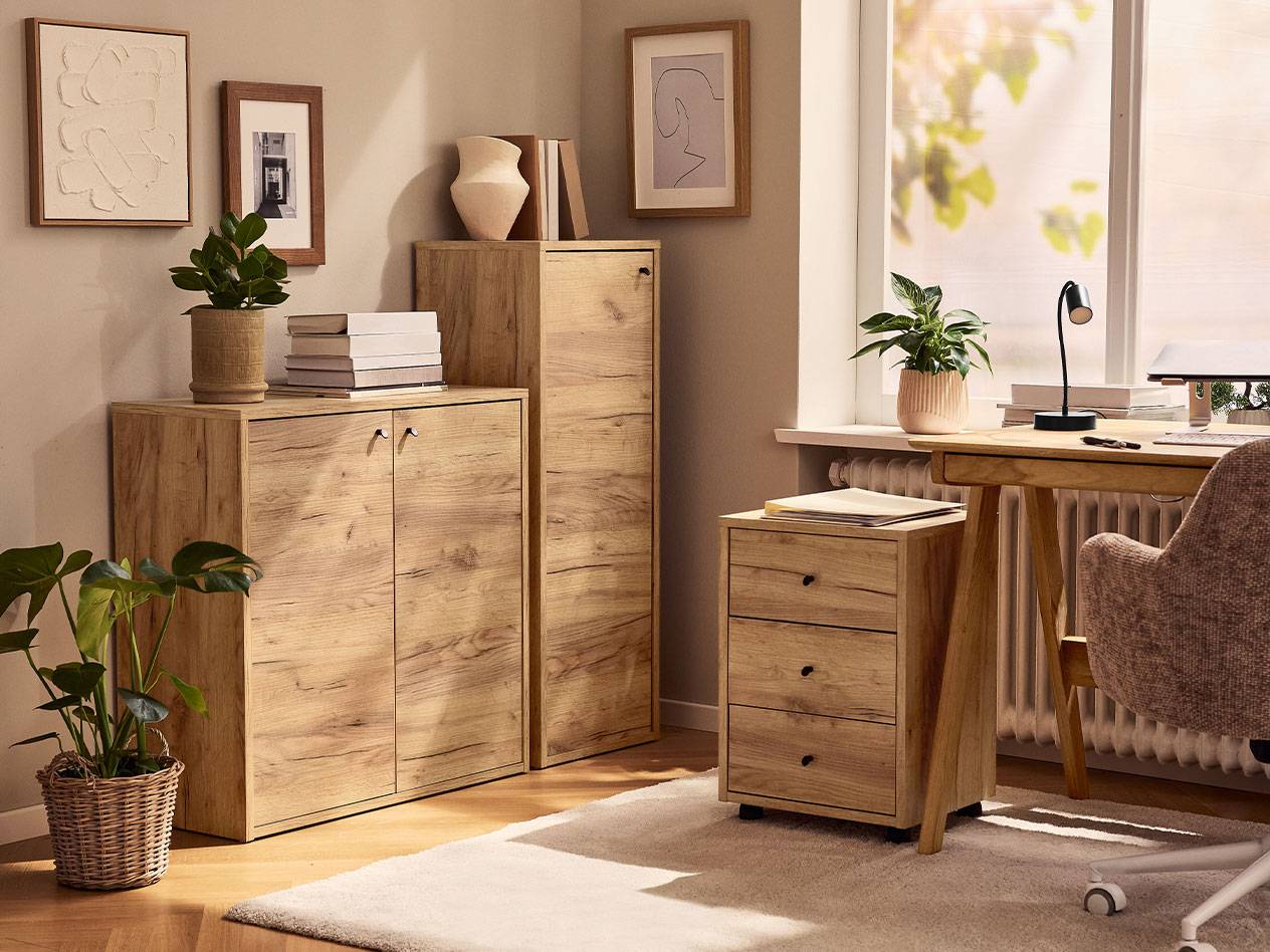 Et hjemmekontor med lyse træskabe, en kontorstol og en skrivebordslampe.