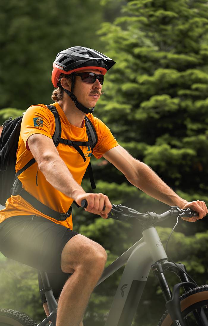 Mand cykler på mountainbike med cykelhjelm og sportstøj.