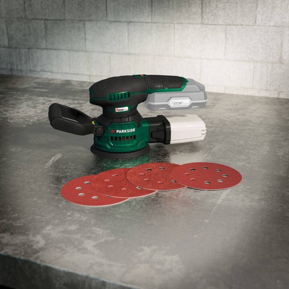 Batteridrevet excentersliber med batteri og slibeskiver på en metaloverflade.