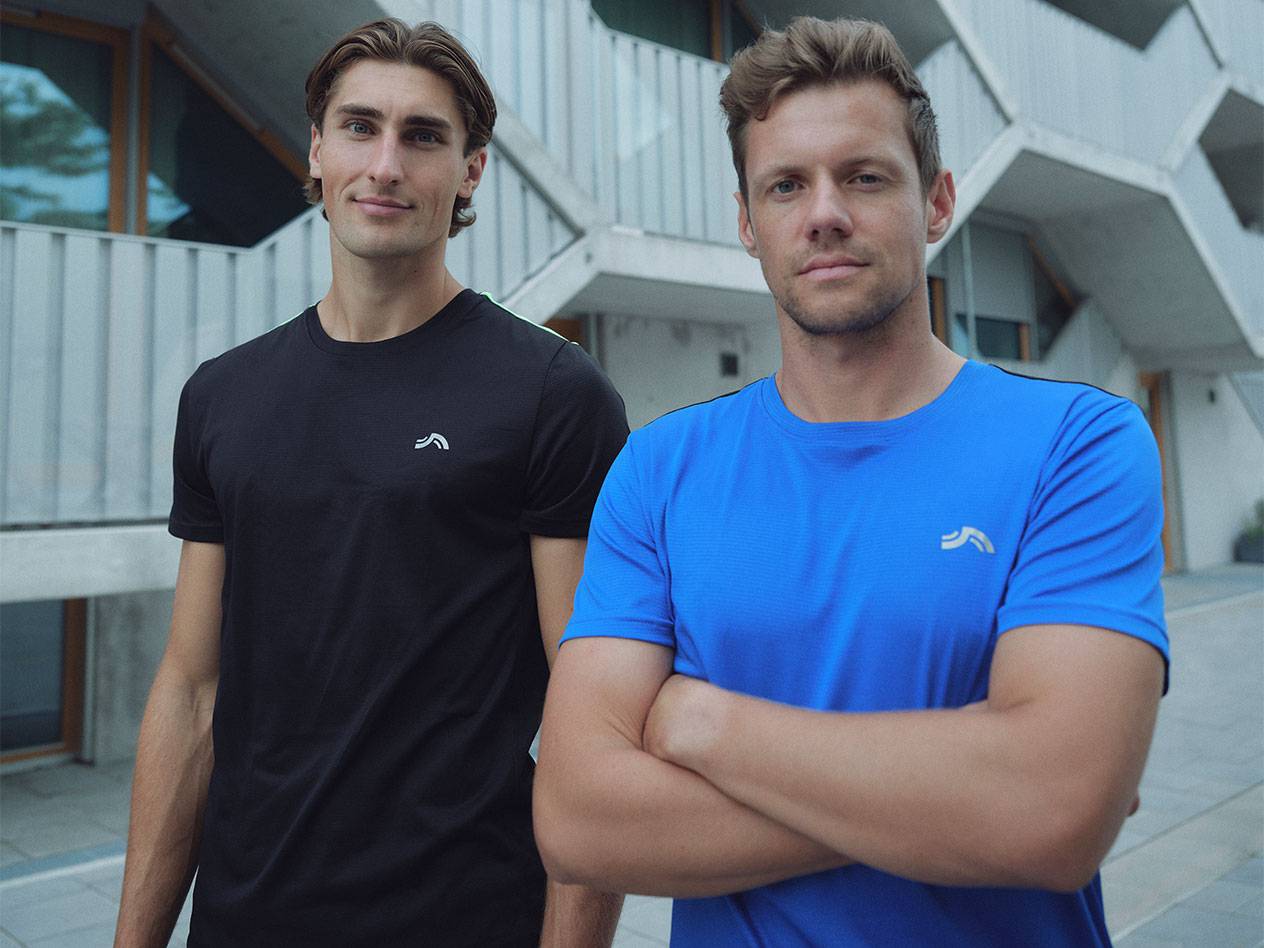 To mænd i sorte og blå sport T-shirts med logo.