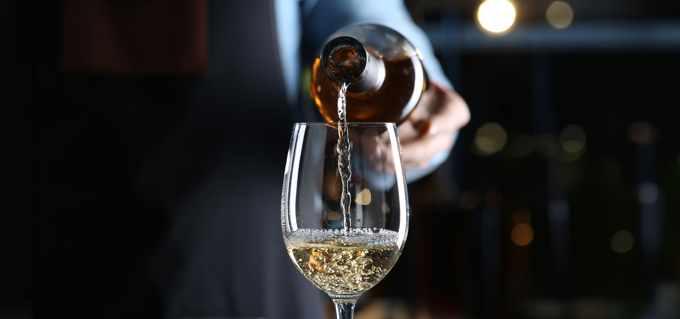 Hvidvin hældes i et glas.
