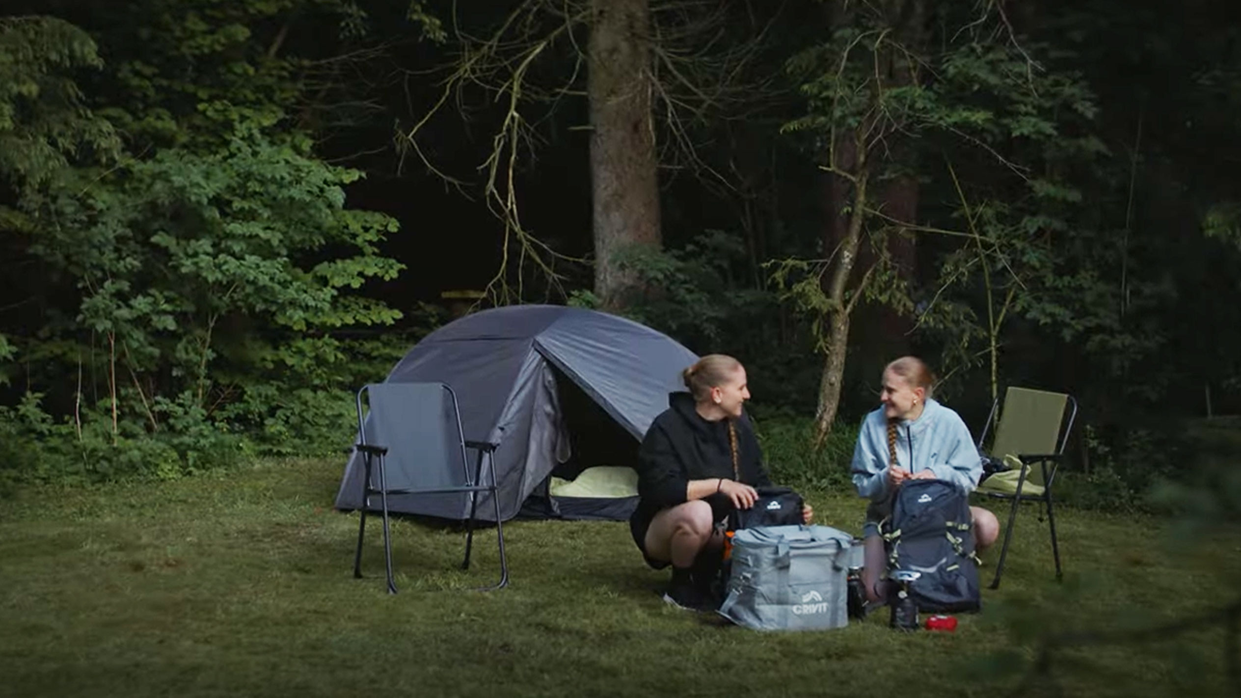 To kvinder camper med et Crivit-telt og sammenklappelige stole.