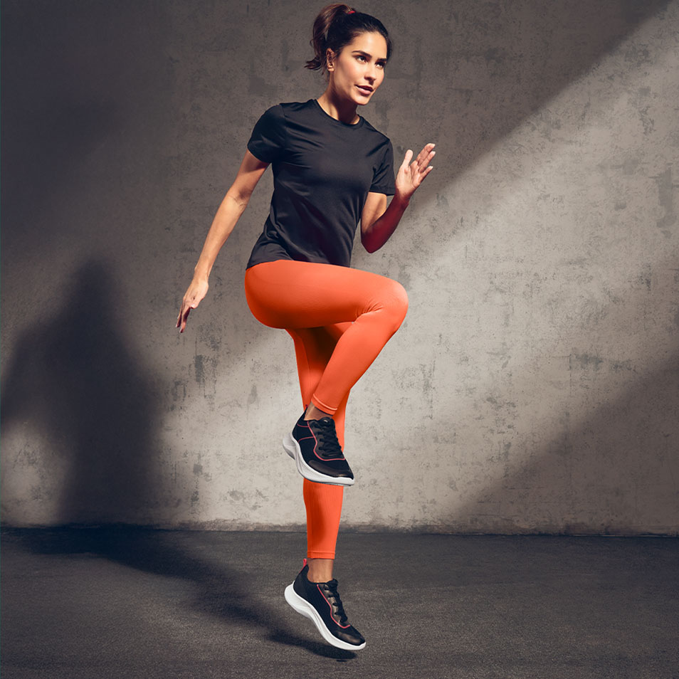 Kvinde i sort sportst-shirt og orange leggings træner