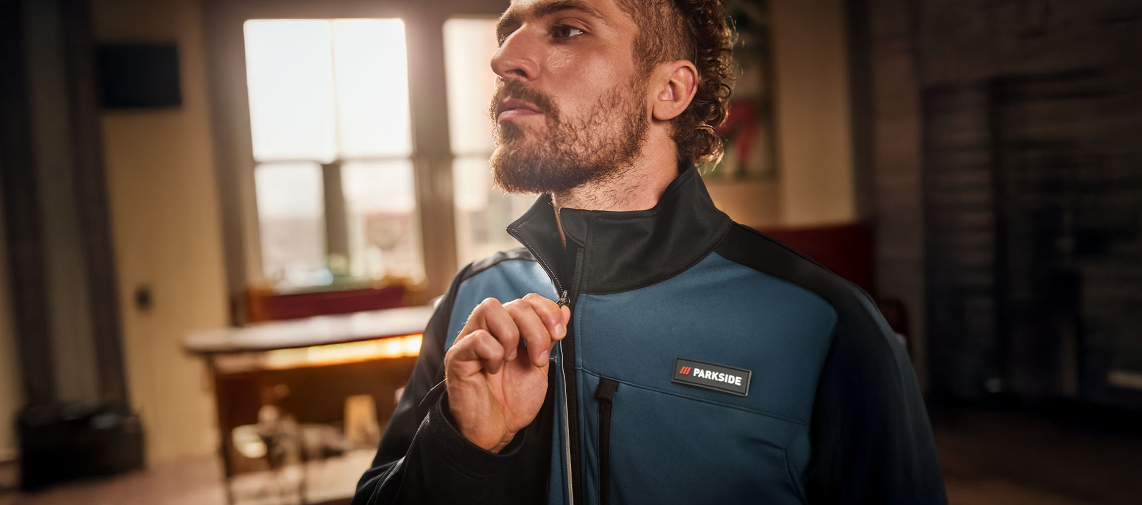 Mand i en blå og sort Parkside arbejdsjakke lyner den op