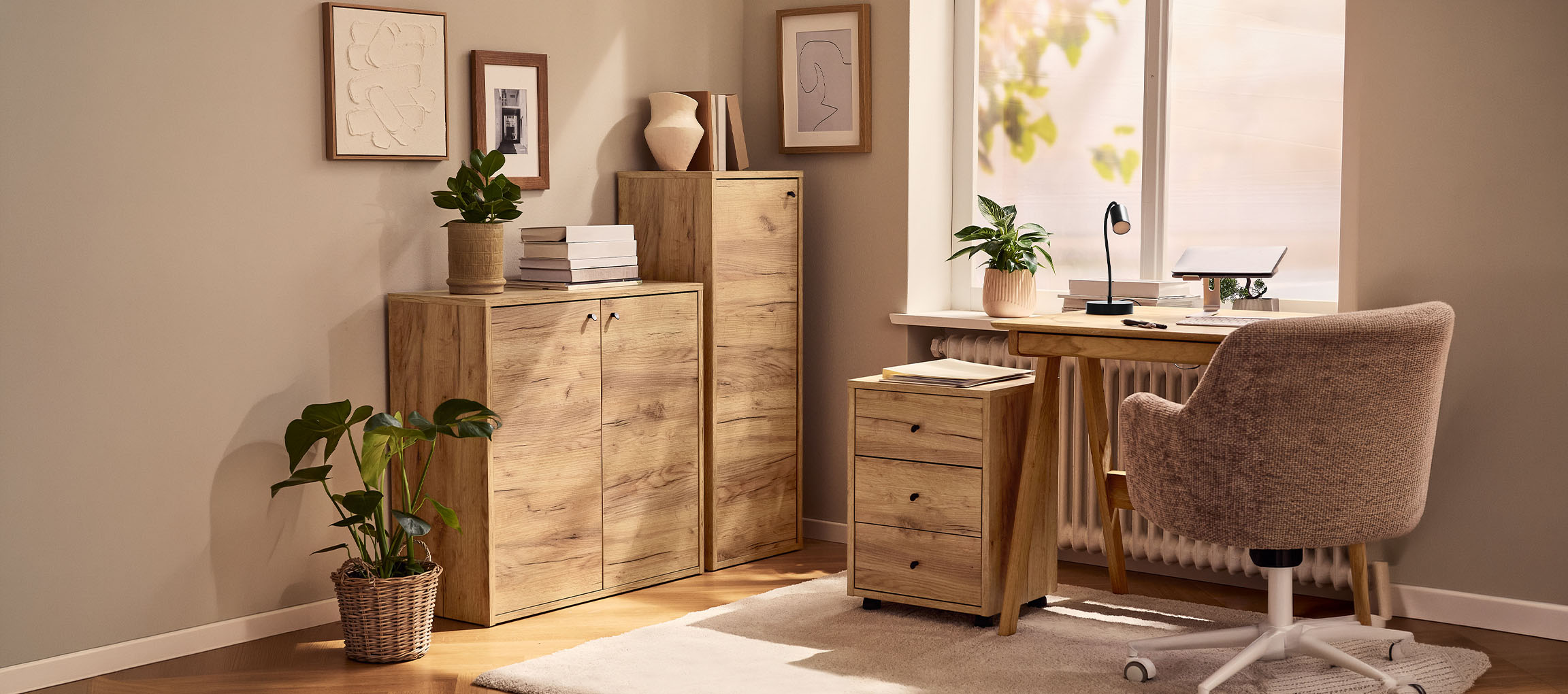 Hjemmekontor med træskabe, skrivebord og stol, dekoreret med planter og billeder.