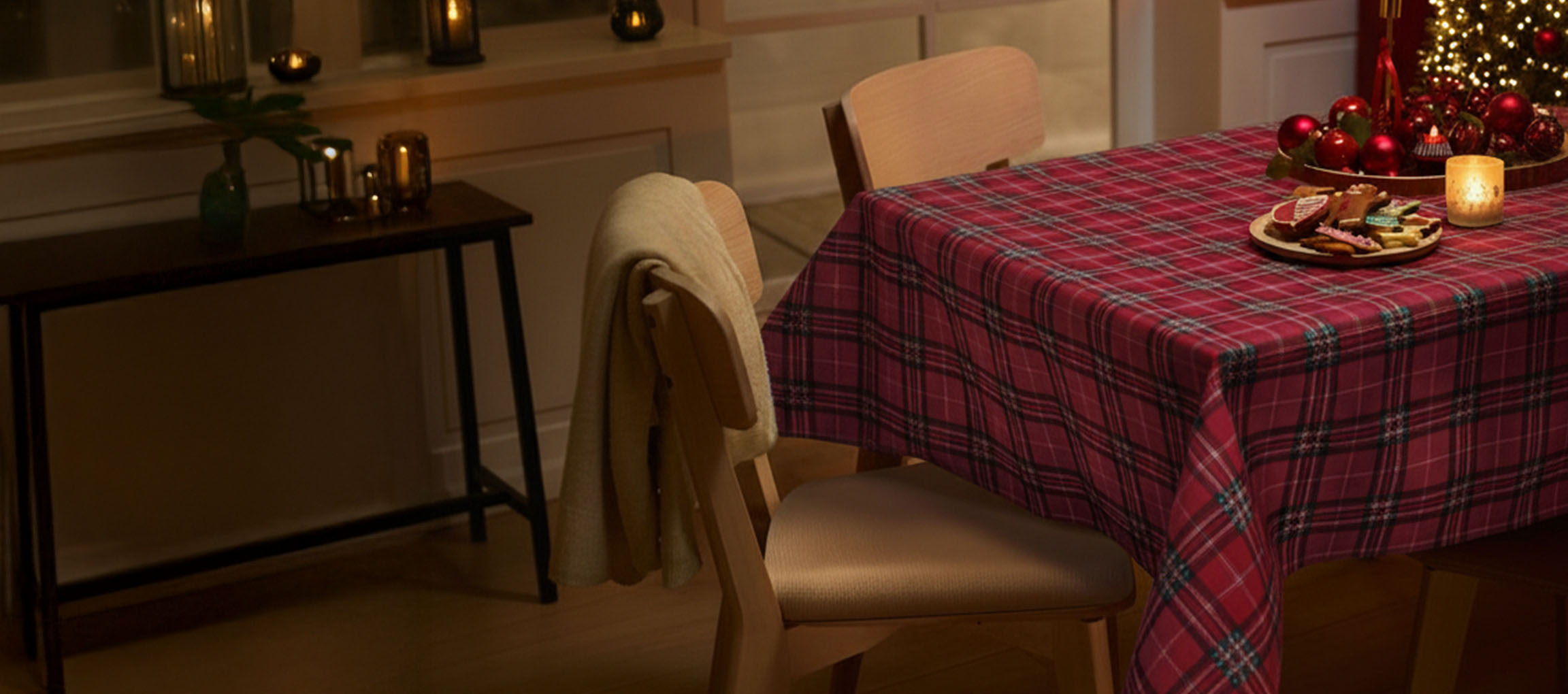 Juleborddækning med rødternet dug, stole og julekager.