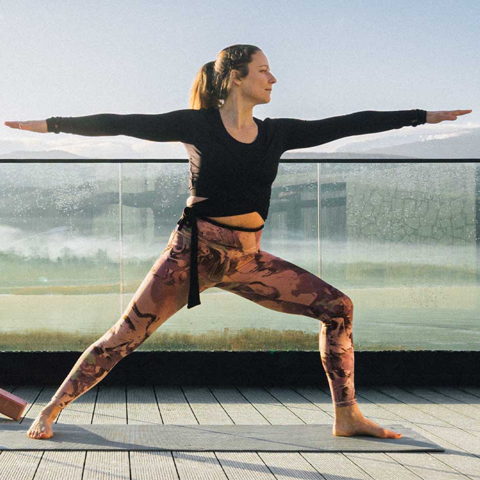 Kvinde i leggings og yogatop på en terrasse