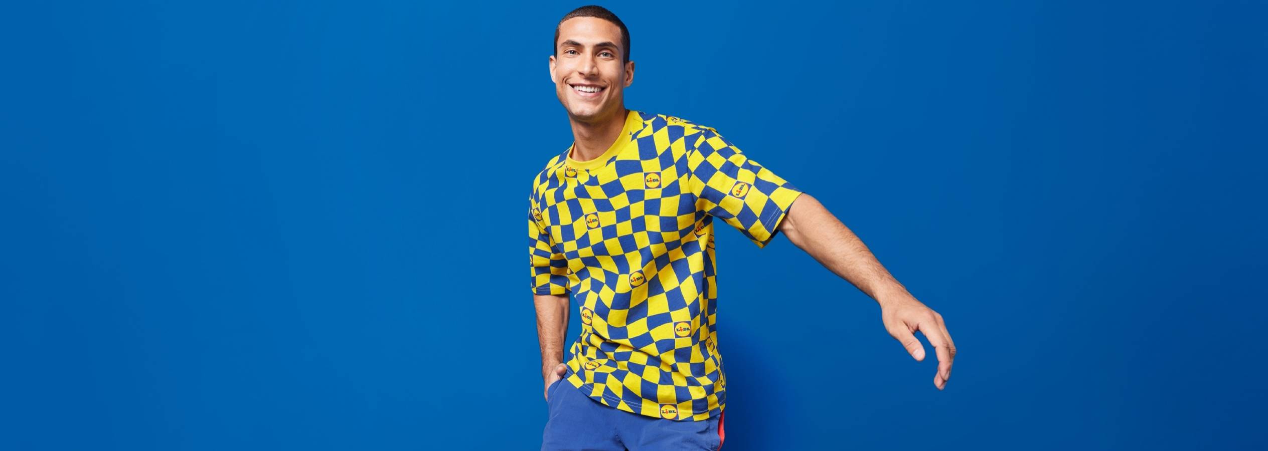 En mand iført en gul og blå ternet T-shirt med Lidl-logoer.