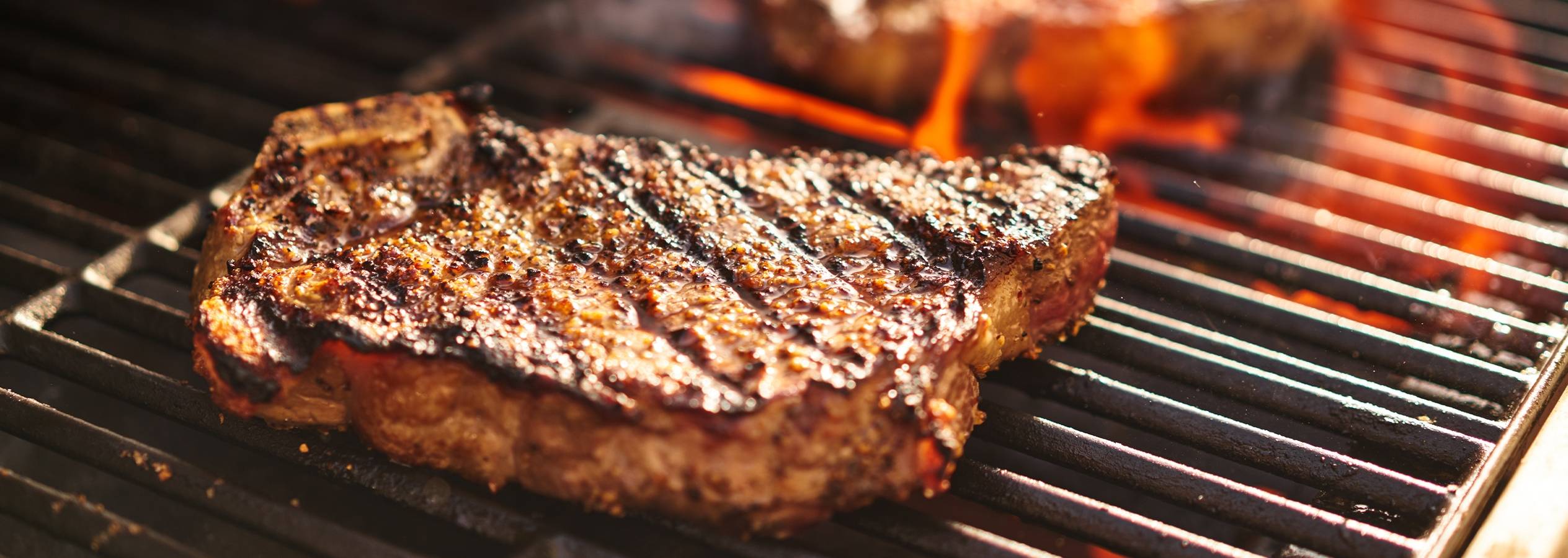 En saftig bøf grilles på en varm grill.