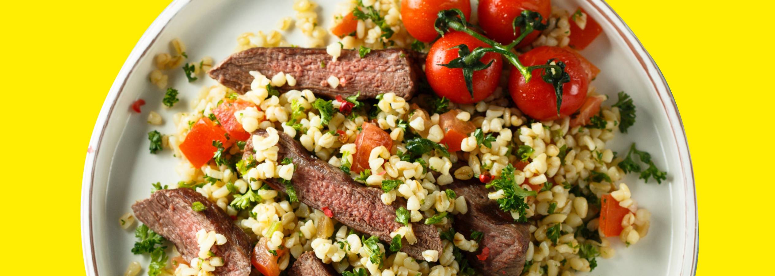 En lækker tallerken med bulgur, oksekød og cherrytomater.