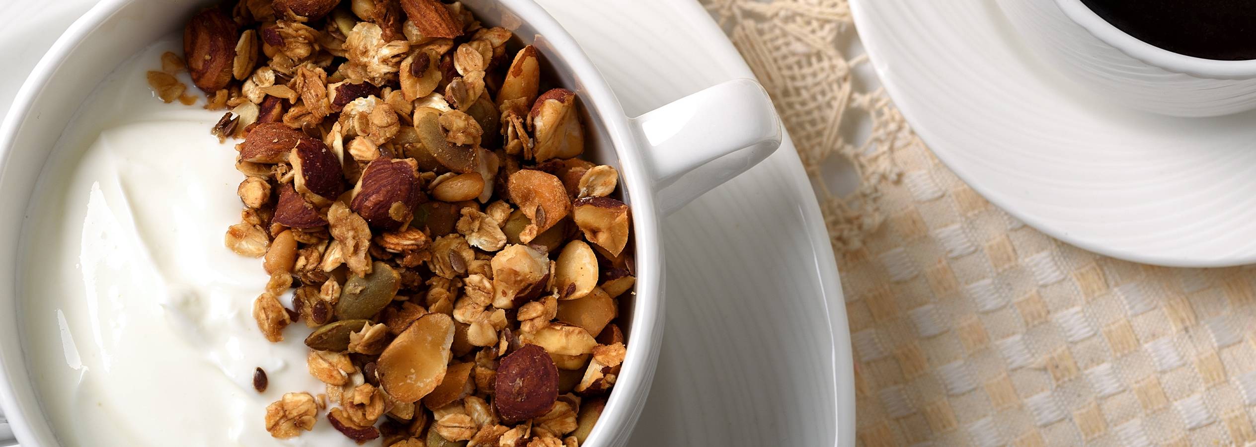 Granola med yoghurt og kaffe på et bord.