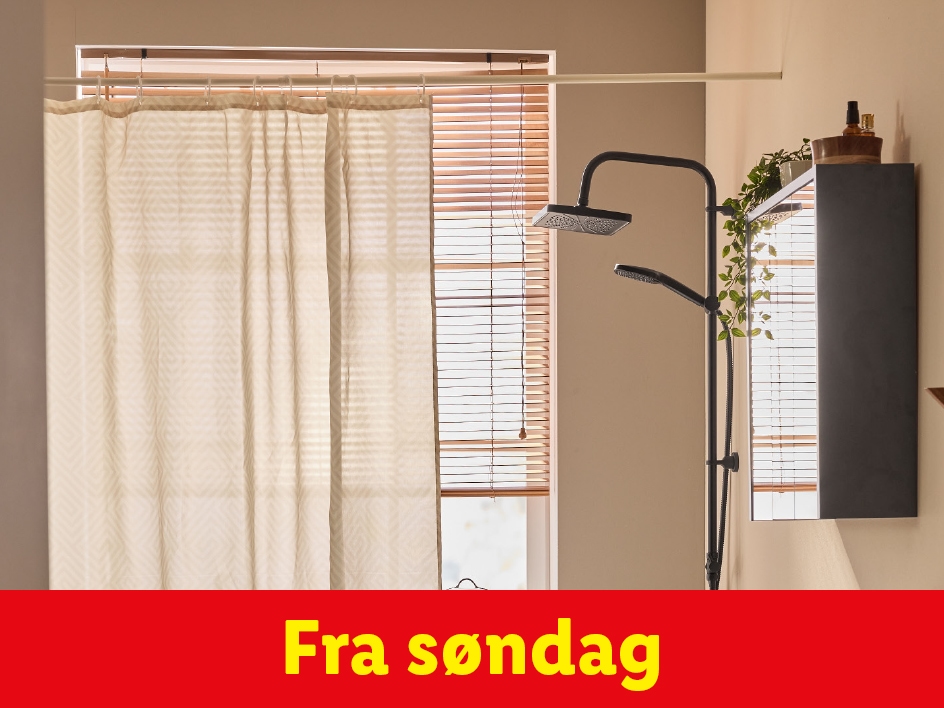 Badeværelse med bruseforhæng, bruser og vinduespersienner.