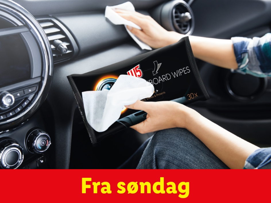 En person rengør et bils instrumentbræt med dashboard-servietter.