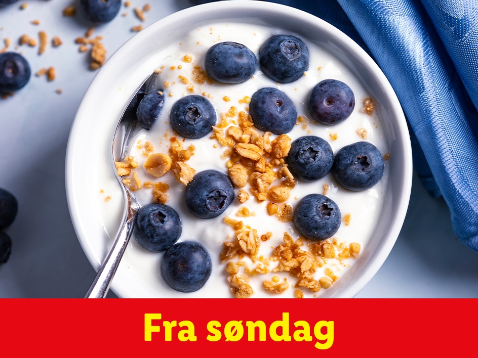 En skål med yoghurt, blåbær og granola med teksten 'Fra søndag'.