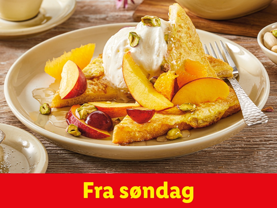 Fransk toast med frugt, is og pistacienødder på en tallerken.